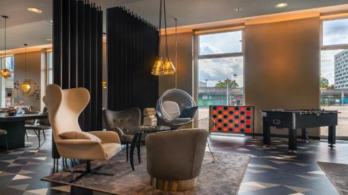 a room with chairs and a table and a mirror at Holiday Inn - the niu, Ridge Halle Central Station by IHG in Halle an der Saale