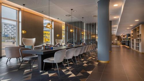 a long dining room with a long table and chairs at Holiday Inn - the niu, Ridge Halle Central Station by IHG in Halle an der Saale