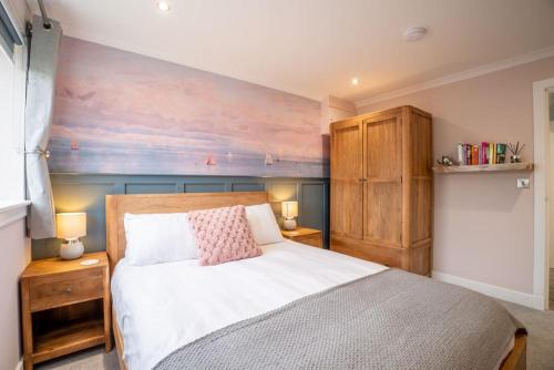 a bedroom with a bed with two night stands and two lamps at Cottage with Hot Tub near Knockhill in Saline
