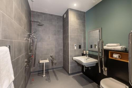 a bathroom with a sink and a shower at Holiday Inn - the niu, Loom Manchester North by IHG in Manchester