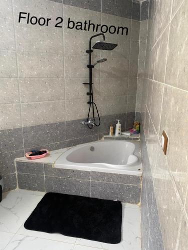 a bathroom with a bath tub and a shower at First Row Sea-Front Chalets Media Village in Marsa Matruh