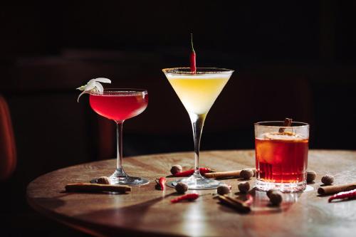 two cocktails on a wooden table withacistacist at voco Orchard Singapore by IHG in Singapore