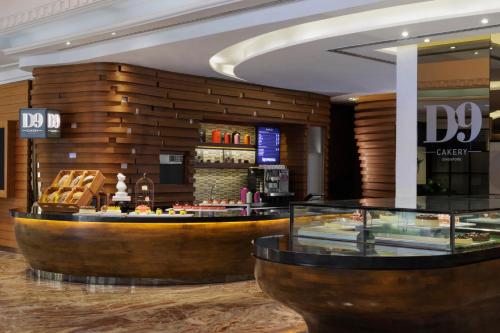 a hotel lobby with a dessert counter and a bar at voco Orchard Singapore by IHG in Singapore