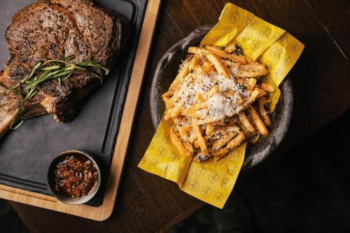 a plate of food with a steak and french fries at voco Orchard Singapore by IHG in Singapore