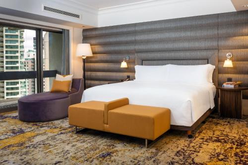 a hotel room with a bed and a chair at voco Orchard Singapore by IHG in Singapore