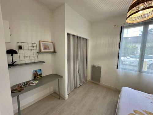 a bedroom with a desk and a window and a bed at Superbe appartement au calme en cœur de village in Saint-Sulpice