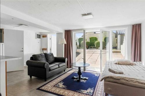a living room with a couch and a bed and a table at Apartments Smålandsstenar in Smålandsstenar