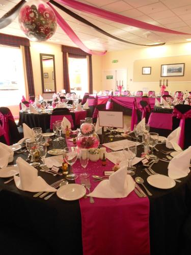 a room filled with tables and chairs with purple tablecloths at The Royal Hotel Tain in Tain