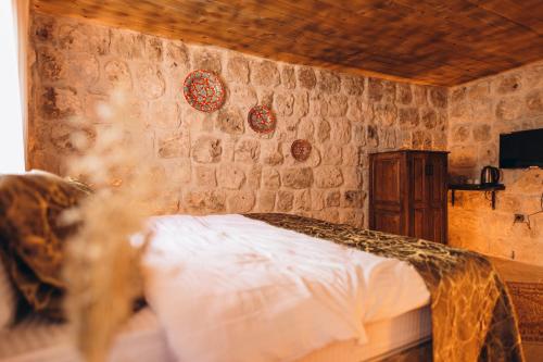 a bedroom with a bed and a stone wall at İsadora Cave Cappadocia in Nevsehir