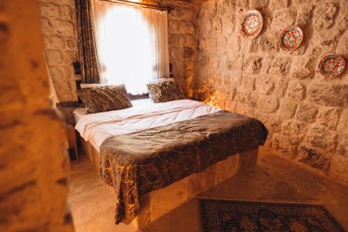 a bedroom with a bed in a stone wall at İsadora Cave Cappadocia in Nevsehir