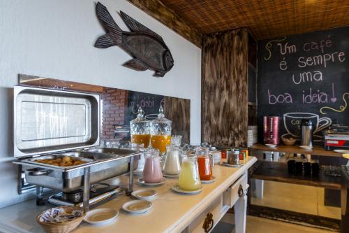 a kitchen with a counter with a sink and a fish on the wall at Costa do Sol Boutique Hotel in Búzios