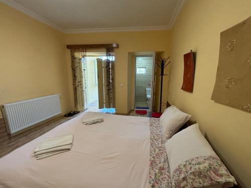 a bedroom with a white bed with two towels on it at Elizabeth's Rooms in Kutaisi