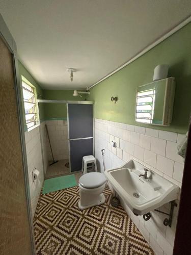 a bathroom with a toilet and a sink at Hotel Shangri-la in Três Corações