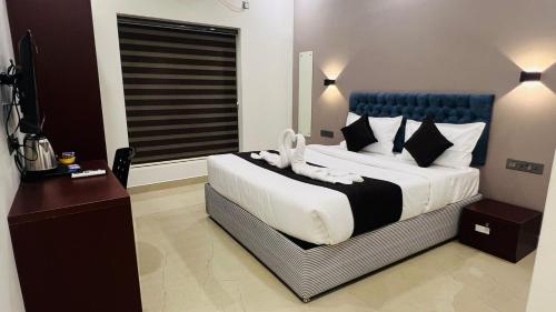 a bedroom with a large bed with a blue headboard at The Lotaz Hotel in Cochin