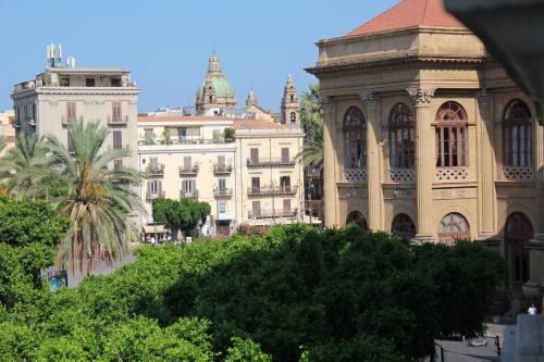 eine Gruppe von Gebäuden mit Bäumen vor ihnen in der Unterkunft FALSTAFF Rooms & Suites in Palermo
