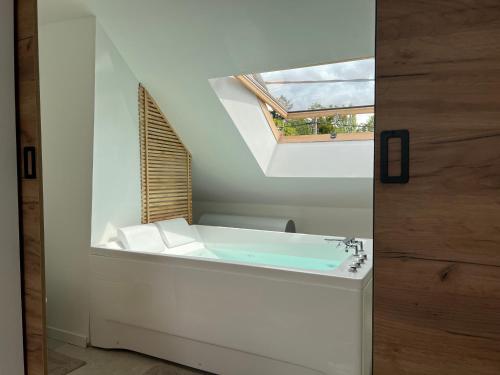 a bathroom with a bath tub with a window at Appartement Chic avec Balneo in Vierzon