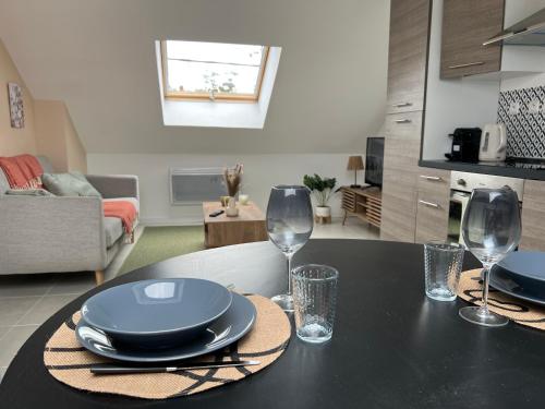 - une table avec des assiettes et des verres à vin dans l'établissement Appartement Chic avec Balneo, à Vierzon