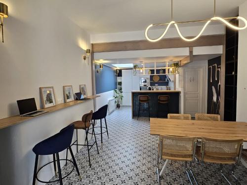 une cuisine et une salle à manger avec une table et des chaises dans l'établissement La Maison Des Petits Sablon, à Amiens