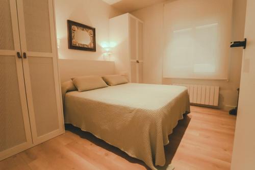 a small bedroom with a bed and a window at SeaHomes Vacations - Seafront Brand New Apt with PKG in Blanes