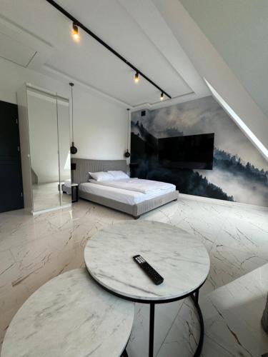 a bedroom with a bed and a table with a remote control at Yeti Studio Apartament Krupówki 73C in Zakopane