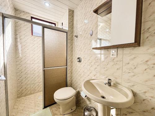une salle de bain avec toilettes et lavabo dans l'établissement Apê Família, A/C e 3 Quartos | 450m Canasvieiras, à Florianópolis