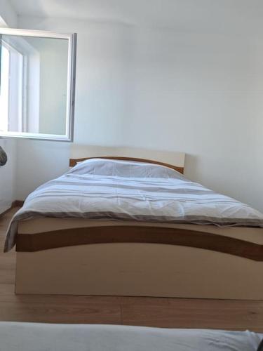 un lit dans une chambre blanche avec une fenêtre dans l'établissement Appartement Sierentz, à Sierentz