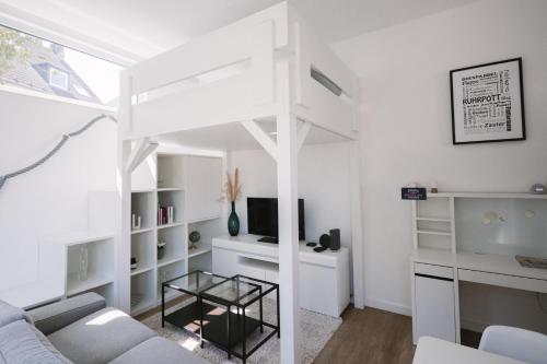 a white living room with a couch and a table at Schöne, moderne Wohnung mit großzügiger Terasse in Essen