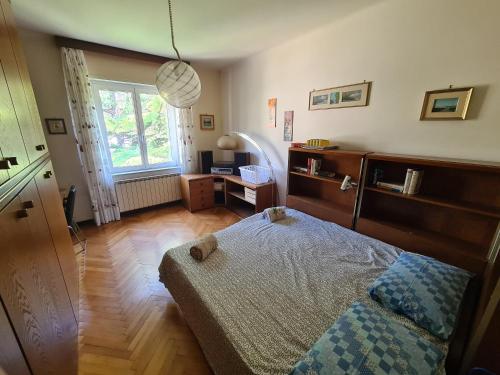 a bedroom with a bed and a desk and a window at Casa Lisa in Trieste