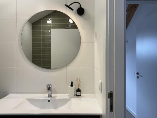 a bathroom with a sink and a mirror at S'apartments in Leiria