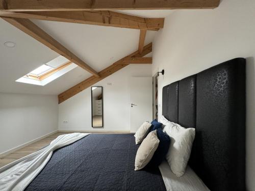a bedroom with a large bed with a black headboard at S'apartments in Leiria