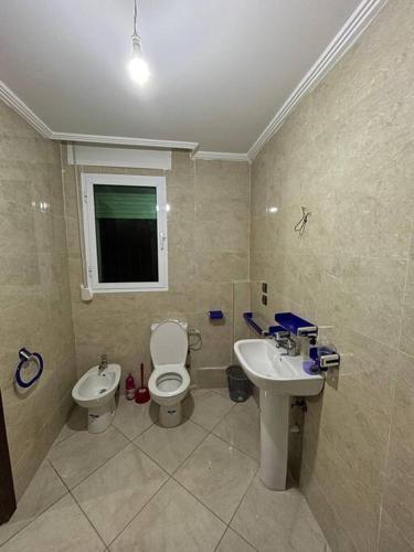 a bathroom with a toilet and a sink at Appartement Ibn batouta in Gzennaïa