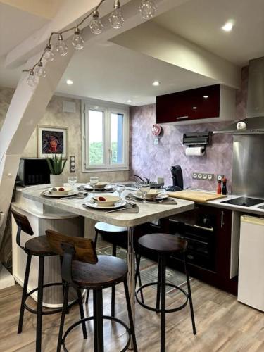 une cuisine avec un îlot et des tabourets de bar dans l'établissement Le Petit Ardennais, à Charleville-Mézières