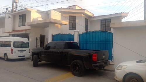 a black truck parked in front of a house at Casa Cedros in Mazatlán