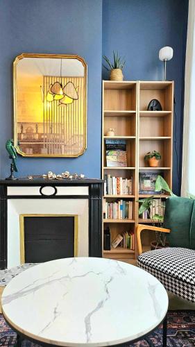 un salon avec une table et une cheminée dans l'établissement La Maison Des Petits Sablon, à Amiens