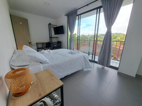 a bedroom with a bed and a balcony at Guatapé Country House Hotel in Guatapé