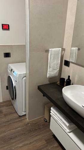 a bathroom with a washing machine and a sink at Case Vacanza Valpolicella in San Pietro in Cariano
