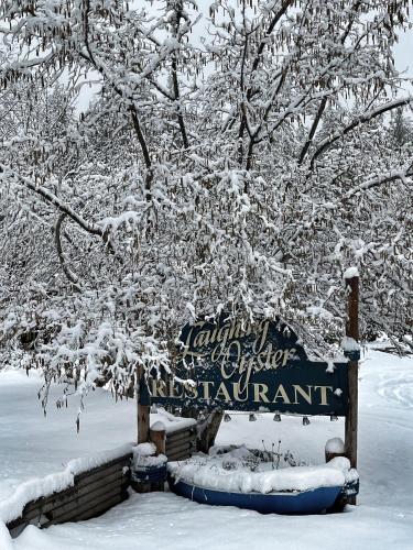 a sign for the entrance to a restaurant covered in snow at Gracies Grotto Cabin in Powell River