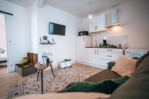 a living room with a couch and a table at LES PETITS ROYS - Proche centre ville - Cosy in Châteauroux