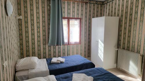 a bedroom with two beds and a window at Auberge de La Vielle Halle in Souppes-sur-Loing