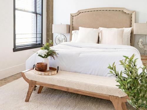 a bedroom with a white bed and a bench with flowers at Fashion Loft 2 bedroom Downtown in Los Angeles