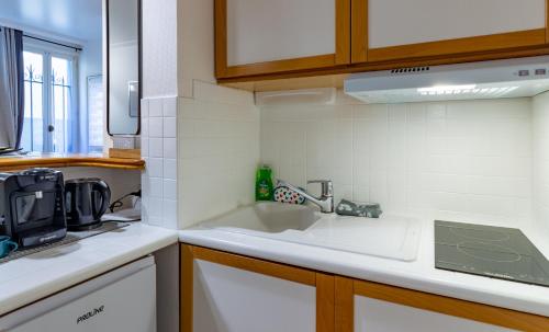 a kitchen with a sink and a counter top at La Maison Verte -Hypercentre-confort in Troyes