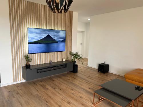 a living room with a couch and a television on a wall at Moderny luxusny domcek s vyhladom na zamok in Prievidza