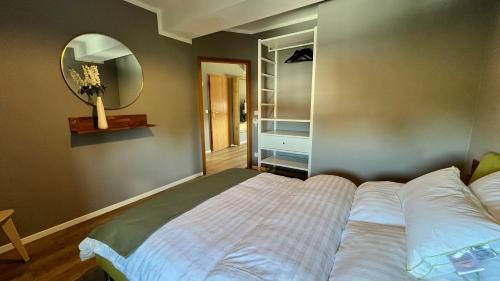 a bedroom with a large bed and a mirror at Chez Phéline in Bochum