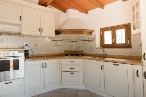 a kitchen with white cabinets and white appliances at Il Mulino di Nonna Sà - Prestige Private Villa in Pietrasanta