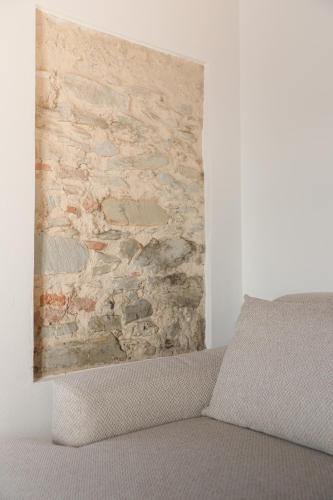 a stone wall in a bedroom with a couch at Il Mulino di Nonna Sà - Prestige Private Villa in Pietrasanta