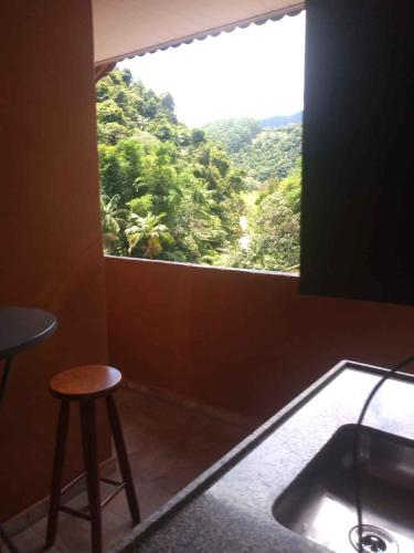 a room with a window with a stool and a table at Suíte WILVIT in São Pedro da Serra