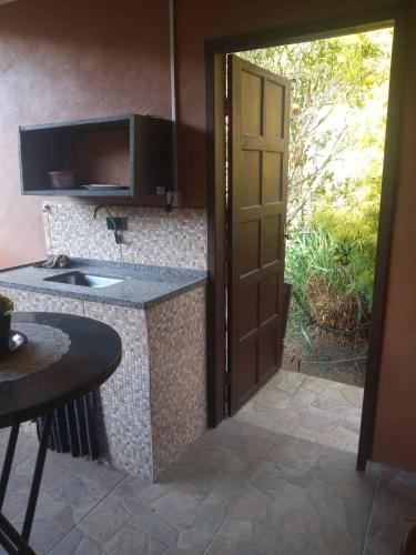 an open door to a kitchen with a sink at Suíte WILVIT in São Pedro da Serra