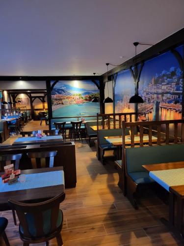 a restaurant with tables and chairs and a large mural at Hotel & Restaurant Heidekrug in Pinneberg in Appen