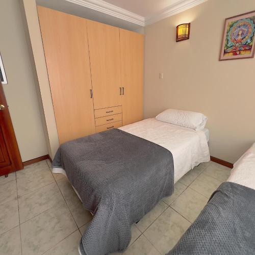 a bedroom with two beds and a cabinet at Departamento en el Centro con Garaje in Loja