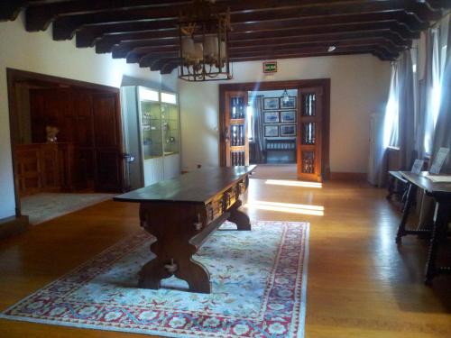 a living room with a wooden table on a rug at Parador de Gredos in Navarredonda de Gredos